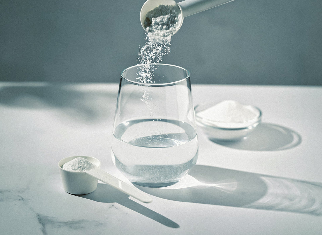 Kreatin-Pulver wird aus einem Messlöffel in ein Glas gegeben – zur Gewichtszunahme durch Kreatin