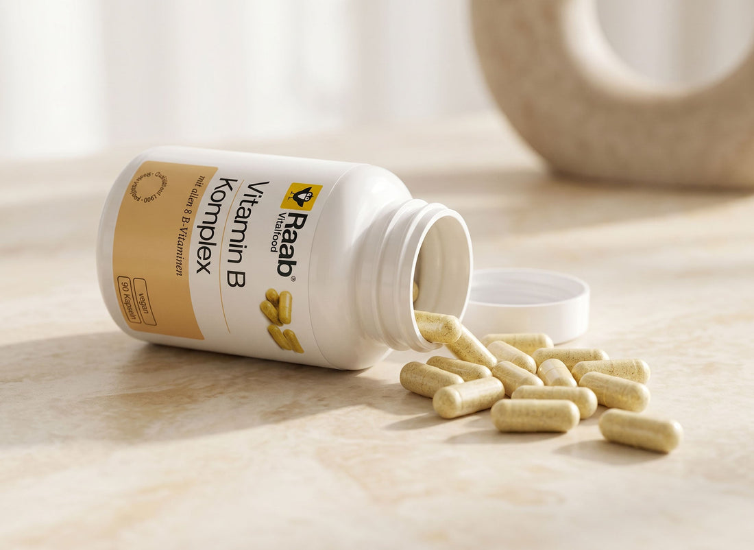 Raab Vitalfood Vitamin B Komplex Kapseln, die aus der Dose auf eine Marmorfläche fallen
