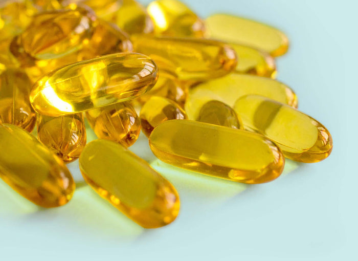 Goldene Ölkapseln in Nahaufnahme – Omega-3-Fettsäuren aus pflanzlichem Algenöl